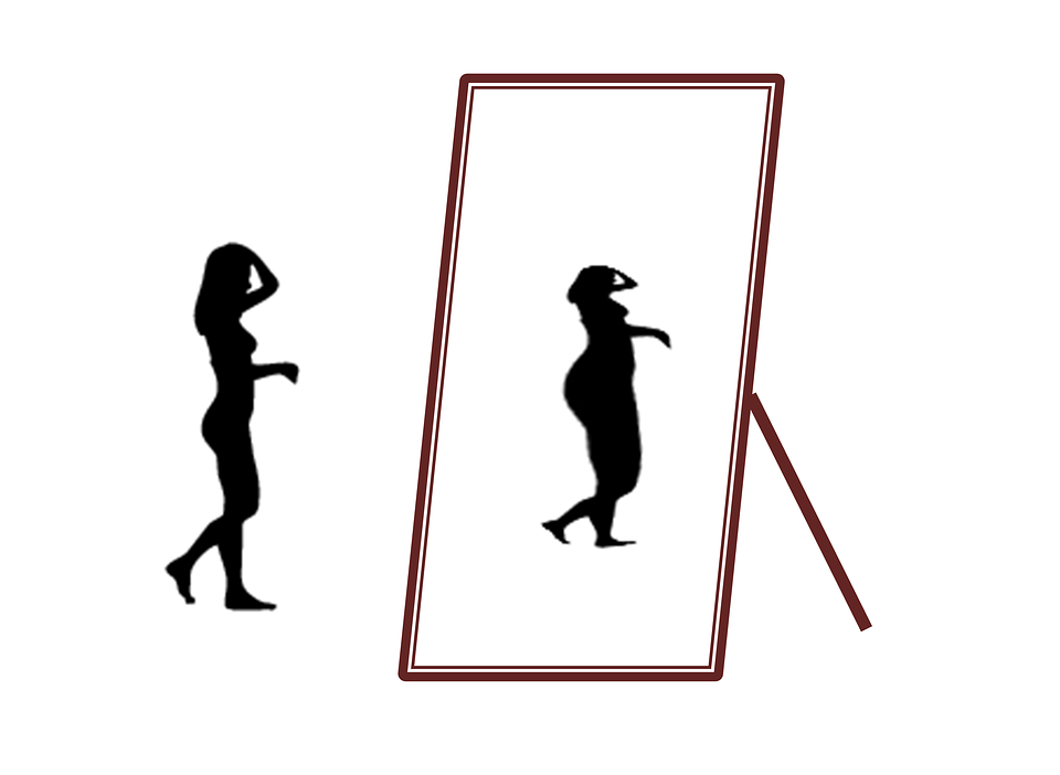 Femme qui se voit grosse dans son miroir.