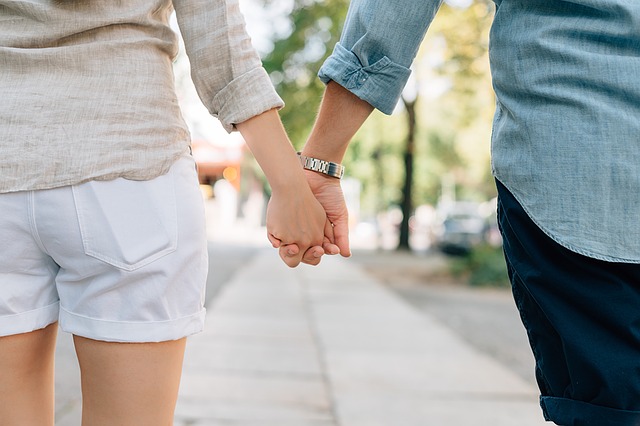 Couple marchant dans la rue en se donnant la main.