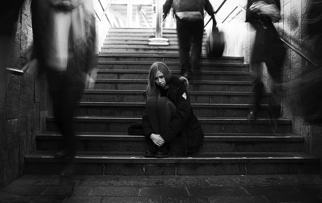 Adolescente assise sur des escaliers, ne supportant pas la foule.