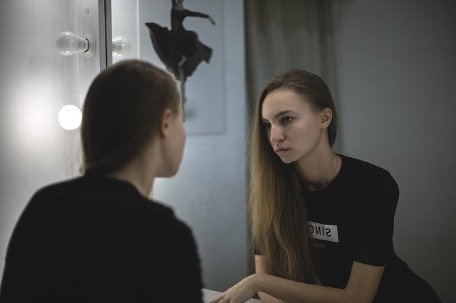Jeune femme et son reflet dans le miroir.